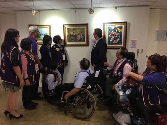 Photo of a group of people viewing a painting by John Feruelo in a museum